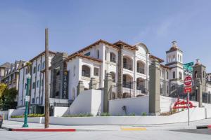 La Quinta Inn & Suites by Wyndham Santa Cruz في سانتا كروز: مبنى ابيض كبير على زاوية شارع