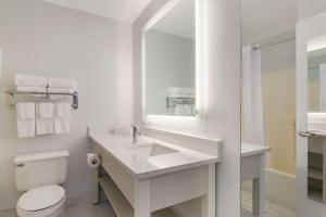 Baño blanco con lavabo y aseo en MainStay Suites Omaha Old Mill en Omaha