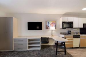 a kitchen with a desk and a table in a room at MainStay Suites Omaha Old Mill in Omaha