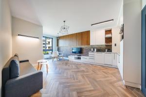 a living room with a couch and a kitchen at Apartamenty Sun & Snow Silva in Gdynia