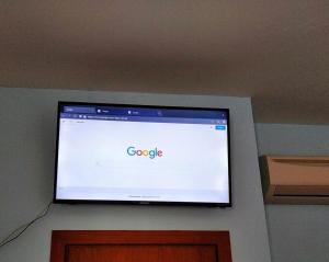 a flat screen tv on a wall with google on it at Hotel magnolia 1000 mt dal casello in Valmontone