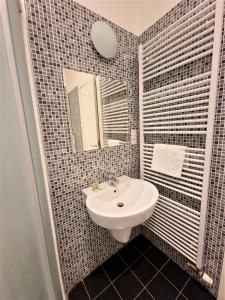 uma casa de banho com um lavatório e um espelho em Reznicka Apartments em Praga