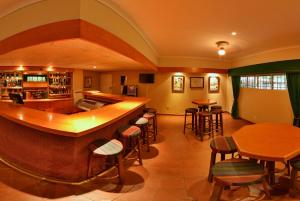 a bar in a restaurant with tables and stools at The Venue Country Hotel & Spa in Hartbeespoort