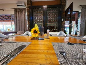 a dining room with a table with a sunflower on it at The Venue Country Hotel & Spa in Hartbeespoort