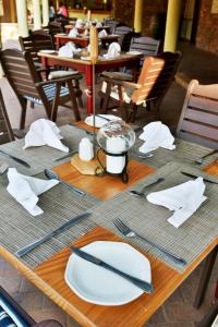 a wooden table with plates and utensils on it at The Venue Country Hotel & Spa in Hartbeespoort
