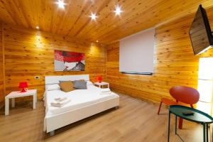 1 dormitorio con 1 cama blanca en una pared de madera en Villa Rosemary, en Marsala