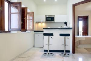 een keuken met twee barkrukken voor een aanrecht bij Apartamento Mirador de la Mezquita in Córdoba