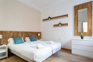 a bedroom with two beds and a mirror at Plaza de Santa Cruz in Seville
