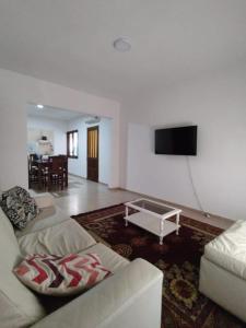 a living room with a couch and a flat screen tv at Casa Lo de Juan in Santa Rosa