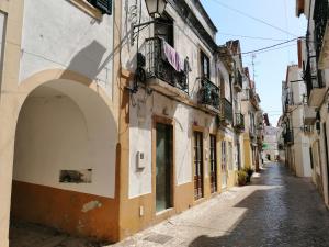 een steegje in een oude stad met gebouwen bij Casa Verde Sal in Alcácer do Sal