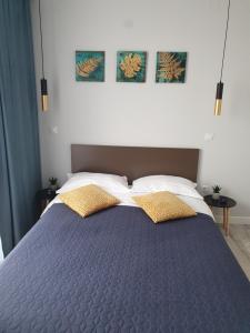 sypialnia z niebieskim łóżkiem i 2 żółtymi poduszkami w obiekcie Apartament Alex w Sybinie