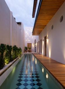 梅里達的住宿－Más Palomas Concept House by Paloma's Hotels - Adults Only，一个带黑白格底地板的室内游泳池