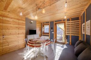 a dining room with wooden walls and a table and chairs at Petit Bleu in Chamois