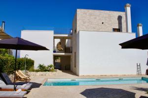 a villa with a swimming pool and two umbrellas at Villa Bora - Ferienhaus am Meer in Slatine