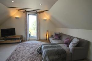uma sala de estar com um sofá e uma televisão em Frith Farm House Cottages em Newnham