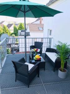 a patio with a green umbrella and chairs and a table at Villa Mannstaedt - Troisdorf - Komplette Unterkunft in Troisdorf