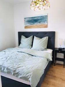 トロイスドルフにあるTroisdorf - City - 64Qm - 1 bis 3 Schlafplätzeの寝室にある白いシーツと枕が置かれたベッド +10枚の写真