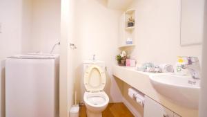 een witte badkamer met een toilet en een wastafel bij TOKYO EXPERT SHINJUKU in Tokyo