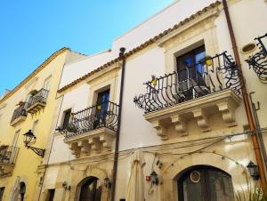 a group of buildings with balconies on a street at Casa Aretusa - Ortigia Holidays in Syracuse