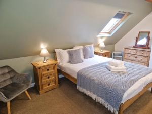 a bedroom with a bed and a chair and a window at Twitchill Farm Holiday Cottage in Hope