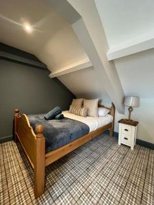 - une chambre mansardée avec un lit en bois dans l'établissement The Boathouse - Hottub - Sleeps 6, à Woodhorn