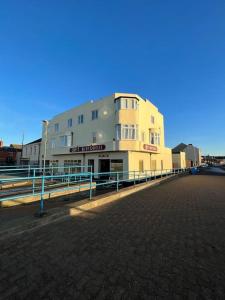 a large white building with a fence in front of it at The Boathouse - Hottub - Sleeps 6 in Woodhorn