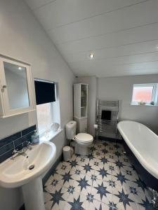 a bathroom with two sinks and a tub and a toilet at The Boathouse - Hottub - Sleeps 6 in Woodhorn