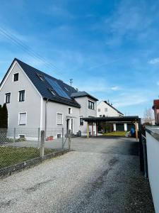 una gran casa blanca con paneles solares. en Guesthouse David, en Augsburg