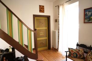 un couloir avec une porte et des escaliers verts et blancs dans l'établissement Villa Molteni, Ville di Fiemme, Varena, à Varena