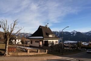 a small white house with a black roof at Villa Molteni, Ville di Fiemme, Varena in Varena