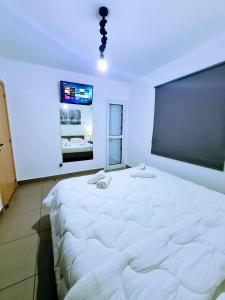 Cama blanca grande en habitación con pizarra en Ayia Anna Apartment, en Ayia Napa