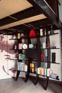 a room with a book shelf with books and a tv at Il Nido delle Taccole in Fezzano
