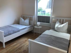 1 dormitorio con 2 camas y ventana en Ferienhaus Anker en Zudar