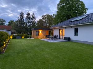 a backyard with a house and a lawn at Ferienhaus Anker in Zudar