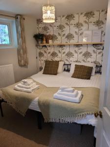 a bedroom with a bed with two towels on it at The Granary Corris on the edge of the Dyfi Forest in Corris