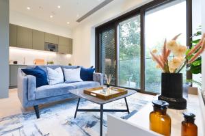 sala de estar con sofá azul y mesa en Haverstock Hill Serviced Apartments by Concept Apartments en Londres