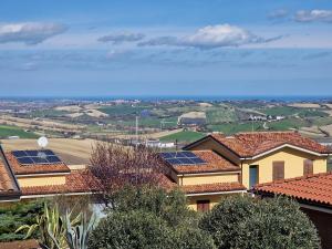 un grupo de casas con paneles solares en sus tejados en W a n d e r l u s t - casa con piscina riscaldata ad uso esclusivo - Marche, en Rustico