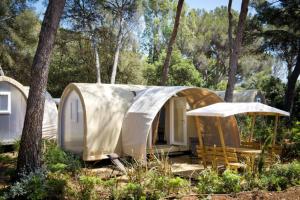 a small home with a tent in the woods at Les Insolites du vélodrome d'Albert in Albert