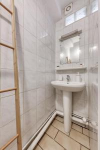 a white bathroom with a sink and a mirror at Paris à la campagne-Parking gratuit-proche Versailles in La Queue-lès-Yvelines