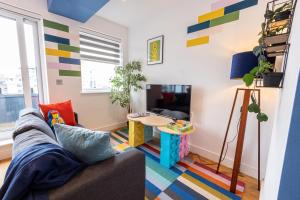 uma sala de estar com um sofá e uma mesa em Legoland Family Fun - Upscale Two Bedroom Apt Near Tube Station with Kid-Friendly Amenities em Slough