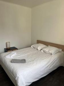 ein großes weißes Bett mit einem Hut darüber in der Unterkunft Le Cocoon, Appartement cosy in Riorges