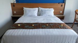 a bedroom with a large bed with a wooden headboard at Bella Vista Premium Homestay in Banyuwangi