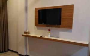een flatscreen-tv aan een muur met een plank bij Bella Vista Premium Homestay in Banyuwangi