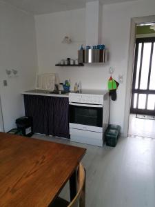 a kitchen with a white stove and a wooden table at B&B Tvolm Ydby Thy in Tvolm