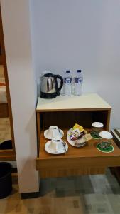 a table with a tea kettle and water bottles on it at Bella Vista Premium Homestay in Banyuwangi