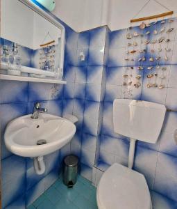 a blue tiled bathroom with a toilet and a sink at "Sun" Bayview apartment in Lixouri