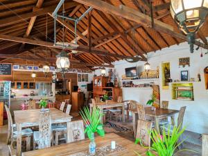 a restaurant with wooden tables and chairs in a room at Deutsches-Eck Rikesti in Lovina