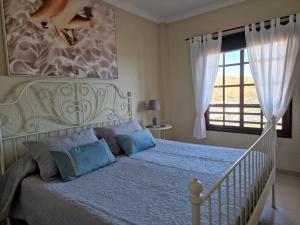 a bedroom with a bed with blue pillows and a window at Balcon del Mar A&V Ocen View Costa del Silencio in Costa Del Silencio +91 photos
