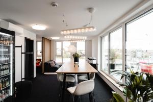 The Place Herzogenaurach - Serviced Apartments في هيرتسوجيناوراخ: غرفة طعام مع طاولة وكراسي ونوافذ