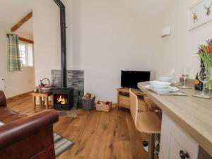 - un salon avec une cheminée et une cuisinière dans l'établissement Primrose Holiday Cottage, Dog Friendly, Hot Tub, Winestead, East Yorkshire Coast, à Hull